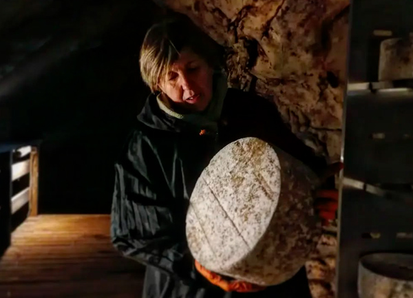Belén Bulnes de la quesería D'Onao con uno de sus quesos en el interior de Cueva Oscura